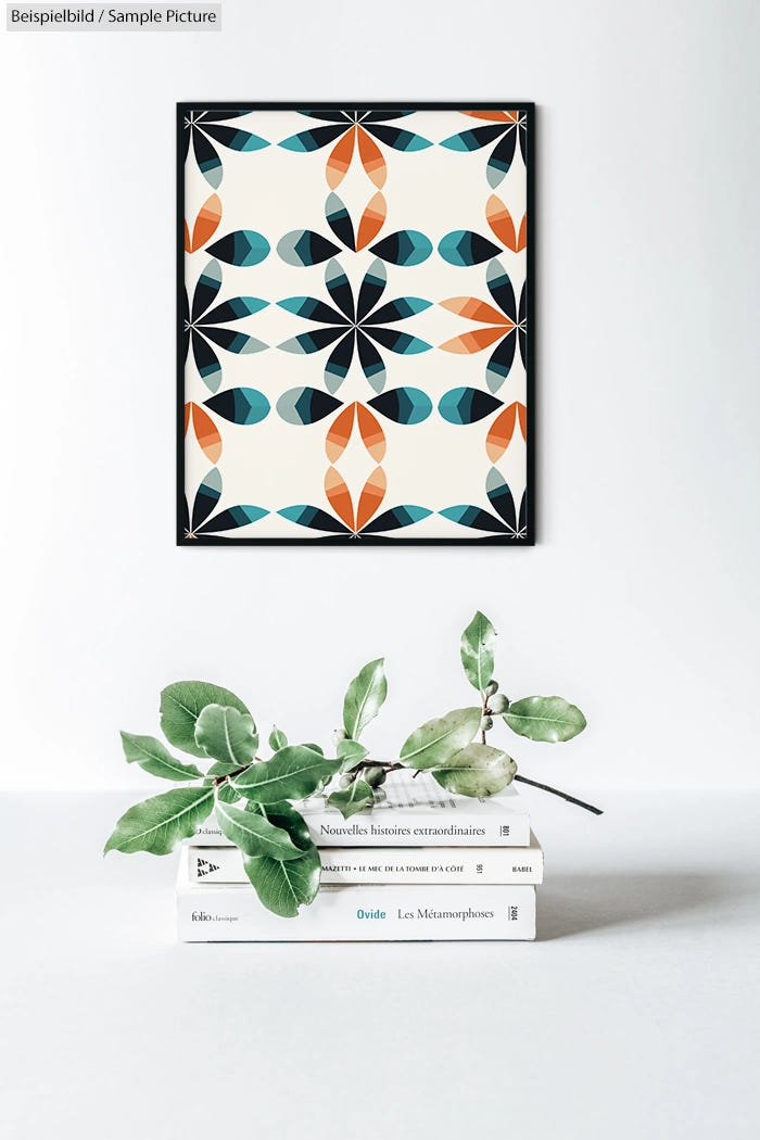 Geometric abstract art with teal, orange, and black shapes over books and foliage on a white surface.