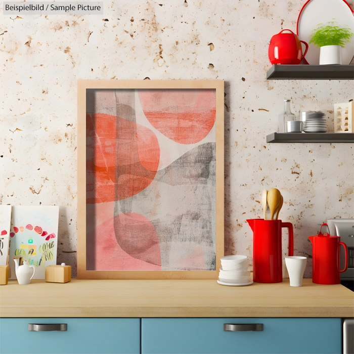 Abstract painting with red and gray shapes on a kitchen countertop, surrounded by mugs and plants.