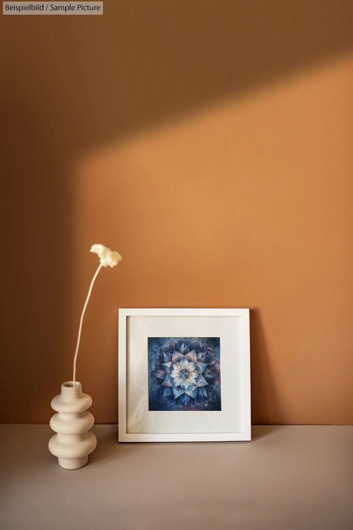 Framed floral artwork on shelf with textured vase and long-stem white flower against a warm brown wall background.