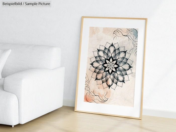 Framed mandala artwork leaning against a white wall by a sofa.