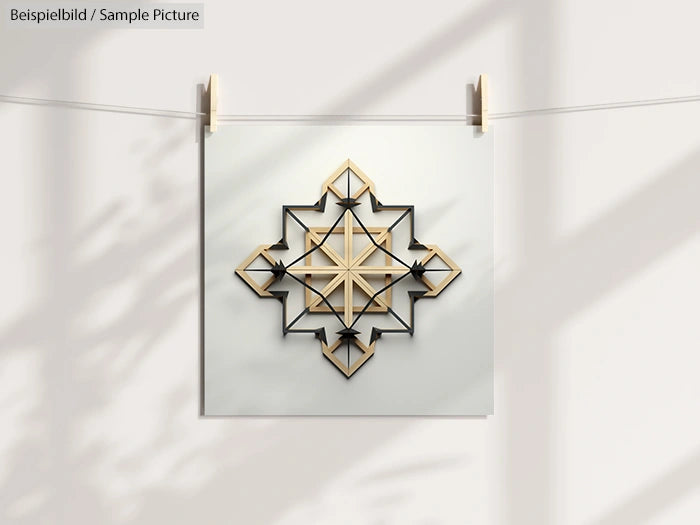 Geometric wall art with symmetrical overlapping squares and arrows in light and dark shades, hanging on a line.