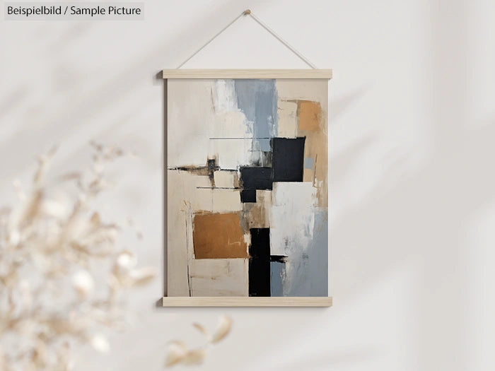 Abstract geometric painting with beige, black, and blue blocks, hanging on a light wall with a wooden frame.