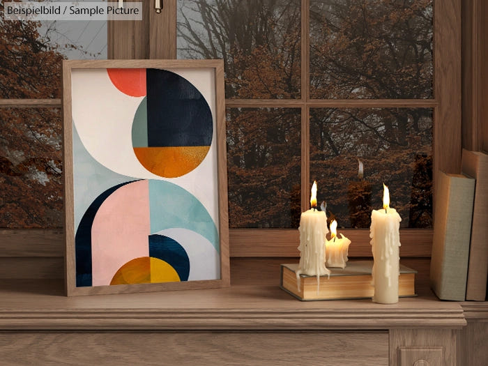 Geometric abstract art in wooden frame, with lit candles and autumn view through window.