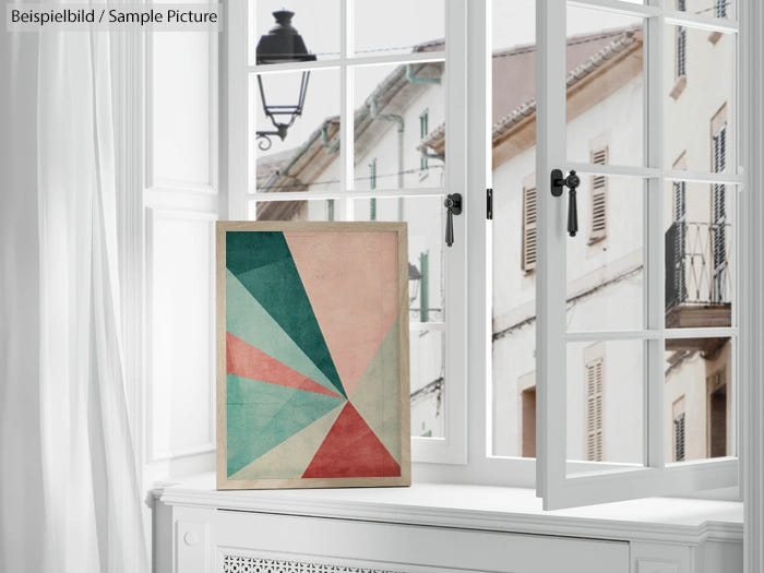 Artistic geometric painting with triangular shapes in pink, green, and blue, displayed on a white windowsill.