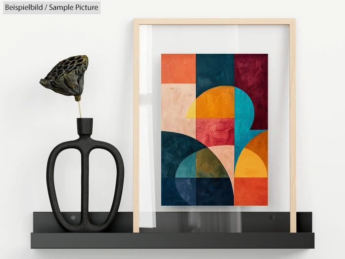 Colorful abstract geometric painting in wooden frame on black shelf with modern vase.