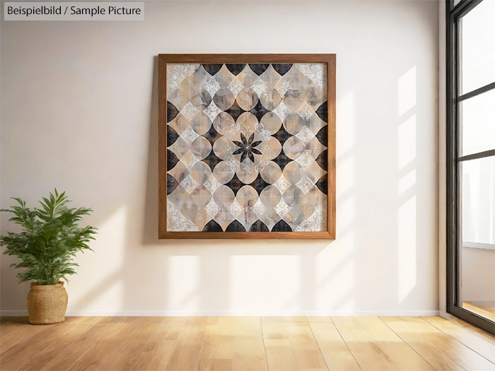 Framed geometric art in a sunlit room with wooden floor and potted plant, casting shadow on white wall.