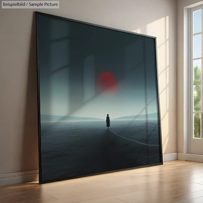 Framed art of a solitary figure on a barren landscape with a red sun, leaning against a wall near a window.