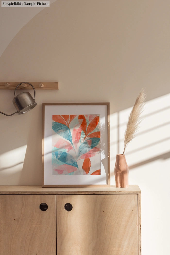 Framed botanical artwork on wooden cabinet, soft shadows, pampas grass in copper vase, and hat hanging above.