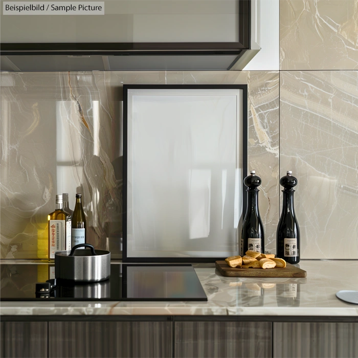 Modern kitchen with marble backsplash, induction cooktop, oil bottles, and bread on a cutting board.