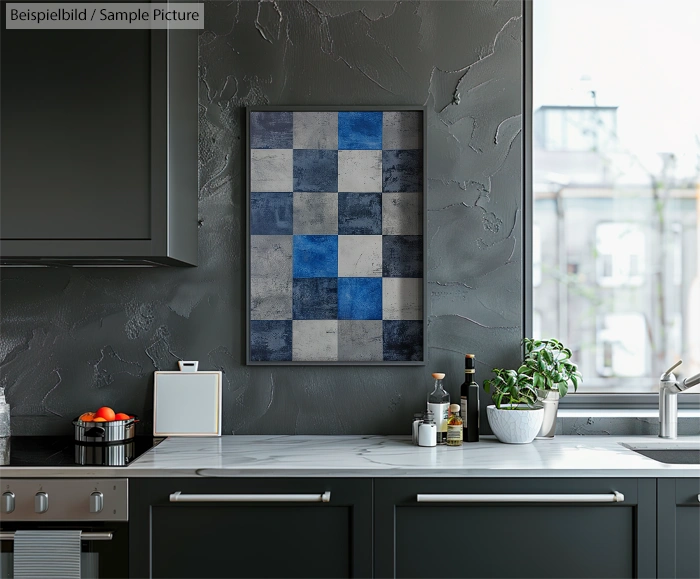 Modern kitchen with dark cabinets, marble countertop, and framed abstract checkered artwork on gray textured wall.