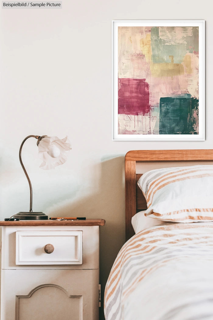 Bedroom interior with abstract art on wall, vintage lamp on nightstand and striped bedspread.