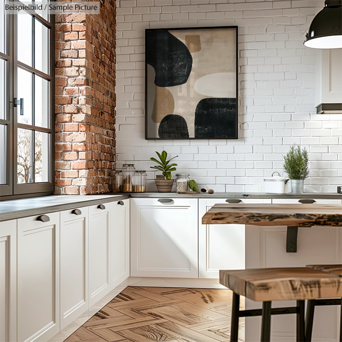 Modern kitchen with white cabinets, brick wall, and abstract art. Wooden countertops and hanging light fixture enhance rustic feel.