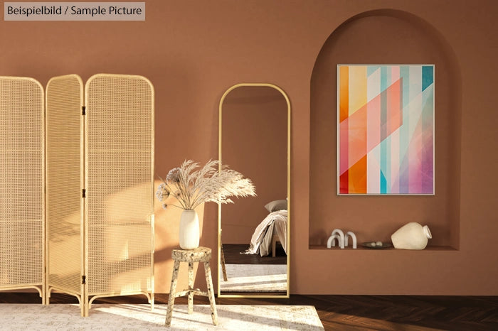 Warm brown room with rattan screen, mirror, colorful geometric art, and pampas grass vase on stool.