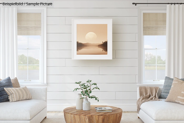 Cozy living room with white paneled walls, featuring two sofas, wood table, and framed landscape art between windows.