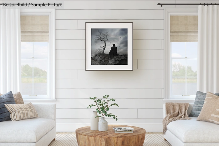 Minimalist living room with white walls and two sofas, featuring a framed nature photograph above a wooden coffee table.