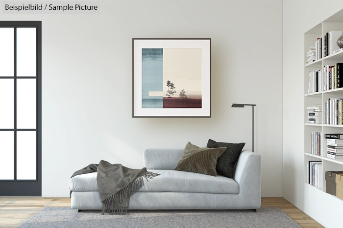 Modern living room with a grey couch, abstract framed artwork, floor lamp, and a bookshelf on hardwood flooring.