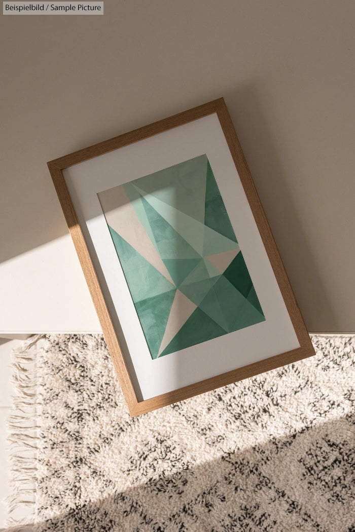 Framed geometric artwork with green and beige triangles on a textured carpet.