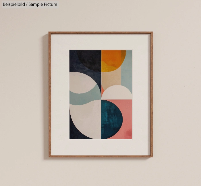 Abstract artwork in a wooden frame with geometric shapes in blue, pink, cream, and mustard on a beige wall.