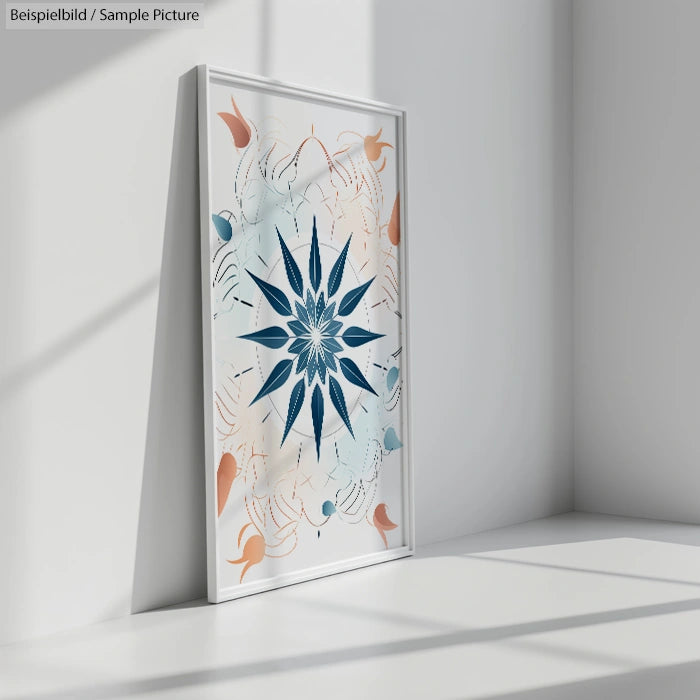 Framed abstract art piece with blue starburst design in sunlit white room corner.