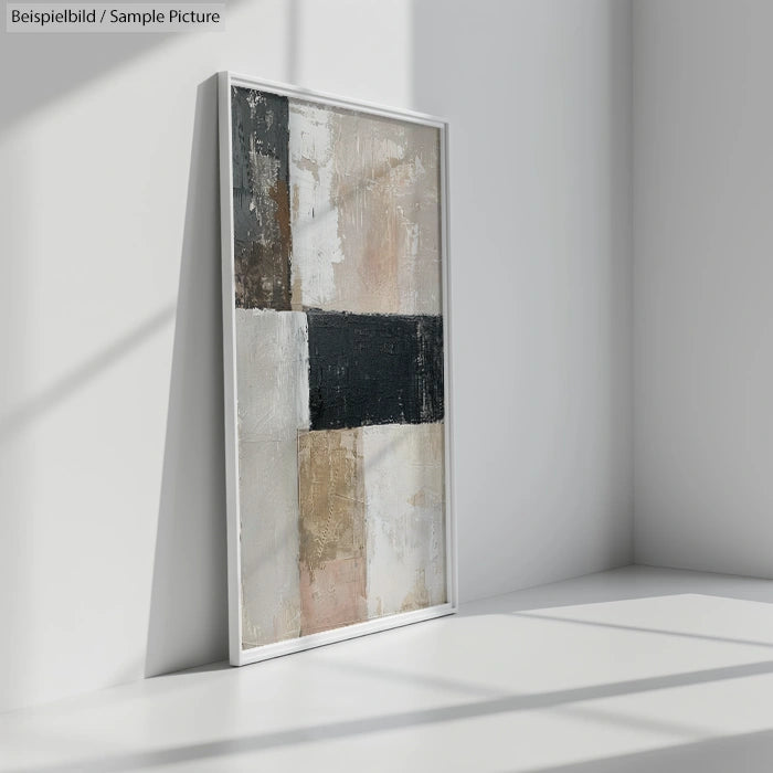 Abstract textured painting with muted colors on canvas, displayed in a white frame leaning against a wall.