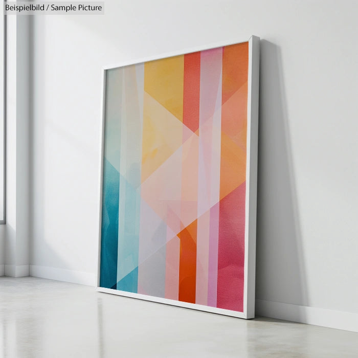 Framed abstract art with pastel geometric patterns leaning against a white wall.