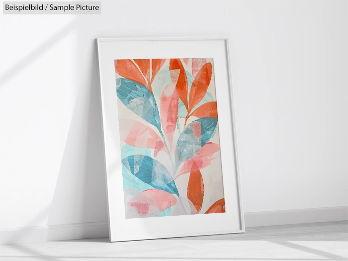 Framed abstract painting with red and blue leaves leaning against a white wall.