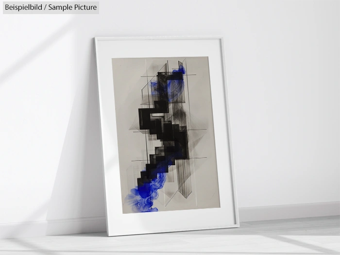 Framed abstract artwork with geometric black shapes and blue accents leaning against a white wall.