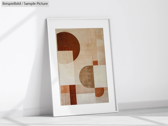 Minimalist abstract art print with geometric shapes in earthy tones against a white background, framed and leaning on wall.