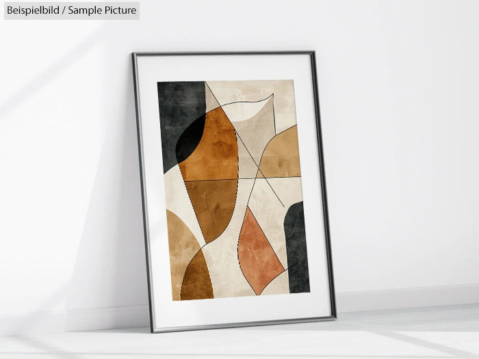 Framed abstract art with geometric shapes in brown, beige, and black tones, leaning against a white wall.