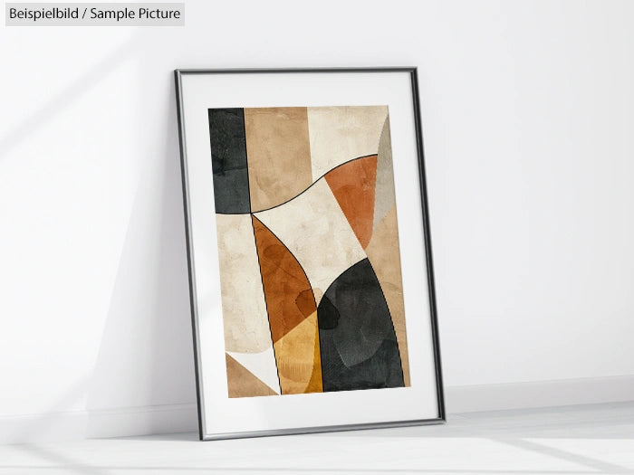 Framed abstract artwork with geometric shapes in beige, black, and brown tones, leaning against a white wall.