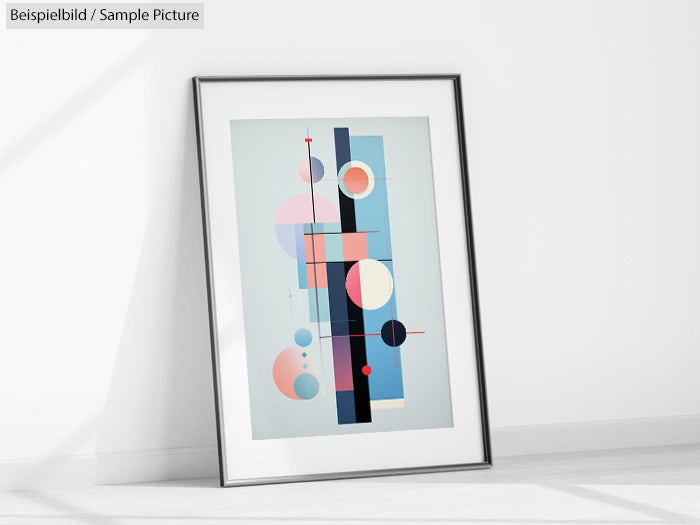 Framed modern abstract art print with geometric shapes in pastel colors leaning against a white wall.