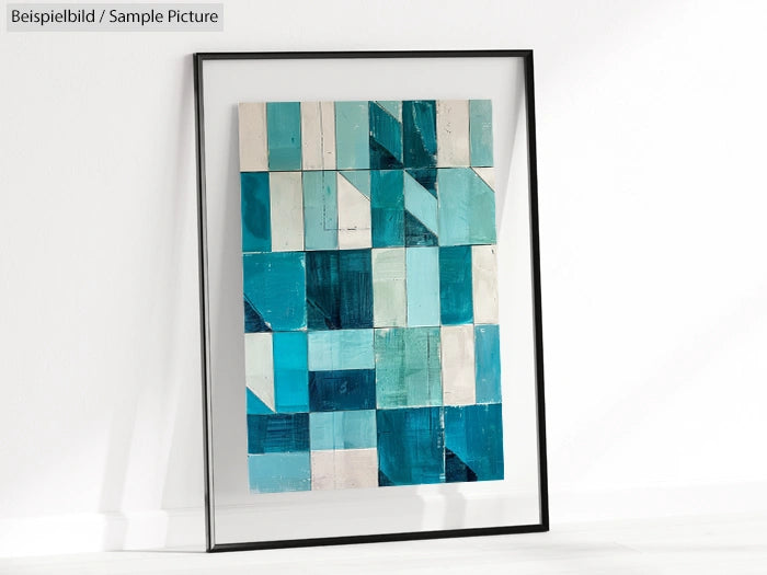 Framed abstract art with blue and teal geometric shapes on a white wall.