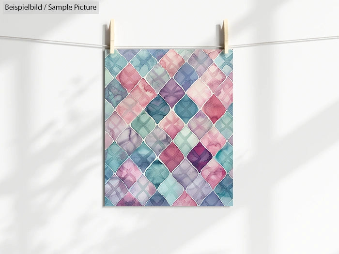 Geometric watercolor pattern with pastel hues clipped to a line against a sunlit background.