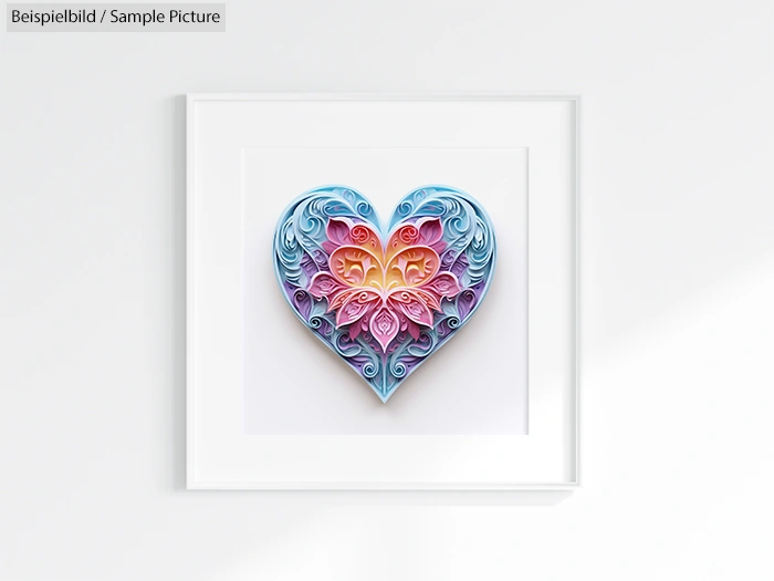 Framed paper quilling art of a heart with intricate pastel patterns, using blue, pink, and purple hues on a white wall.