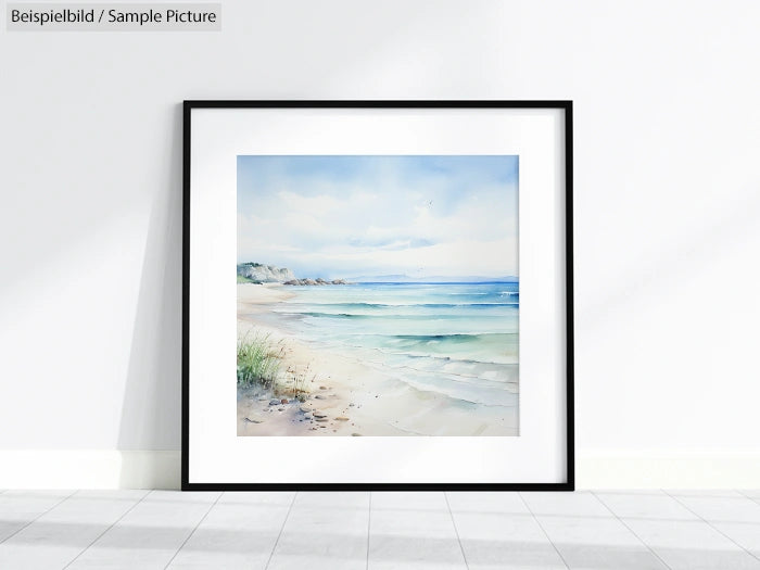 Framed watercolor painting depicting a serene beach landscape with gentle waves and a cloudy sky.