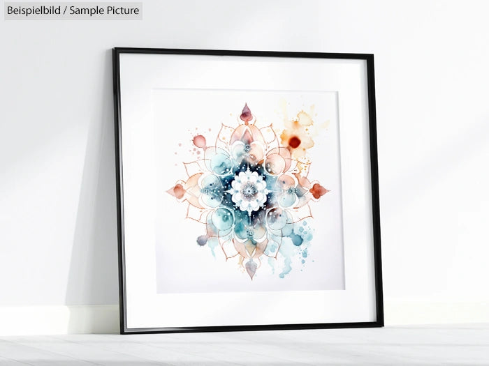 Framed watercolor mandala with blue, orange, and pink hues, placed against a white wall.