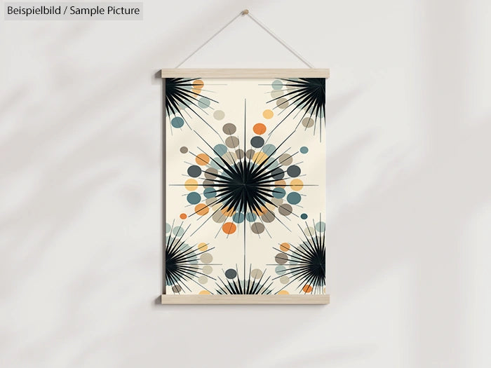 Abstract art print with starburst patterns in blue, orange, and gray on a light background, hung on a wall.