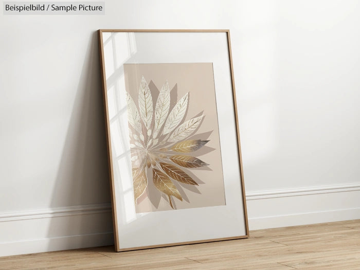 Framed artwork with metallic leaf design leaning against a wall in a sunlit room.