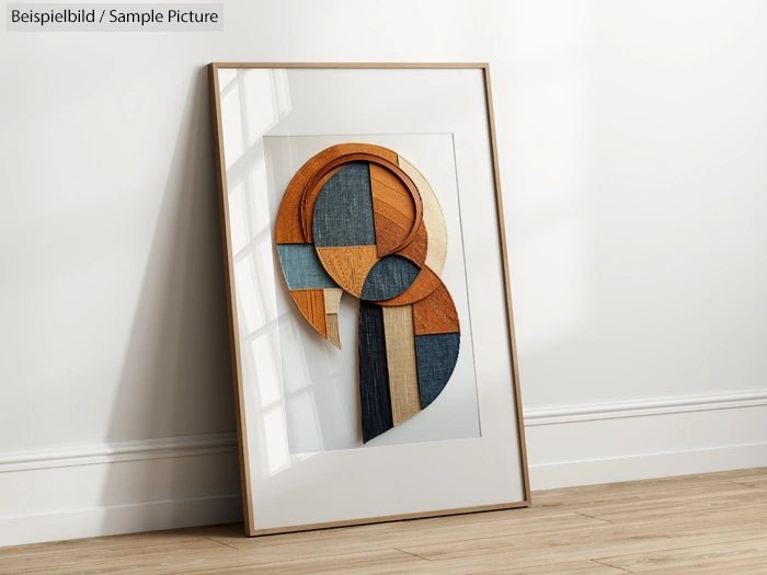 Framed abstract art piece with circular and rectangular wooden shapes against a white background, leaning on a wall.