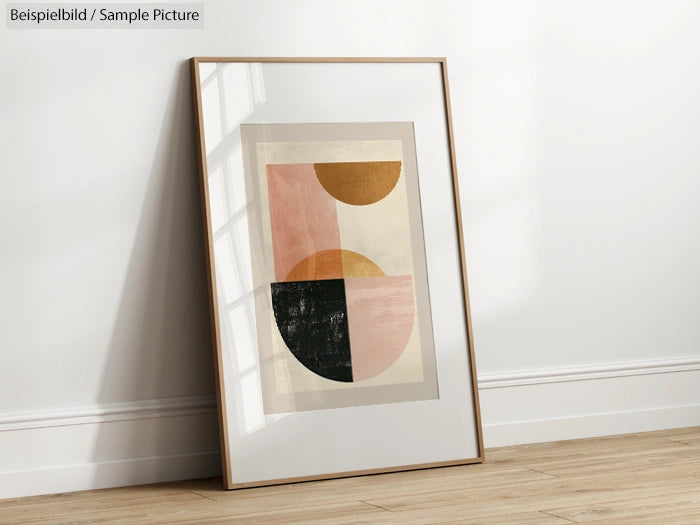 Framed geometric abstract art leaning against a white wall on a wooden floor.