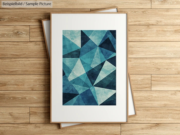 Framed abstract art with blue triangle pattern on wood floor background.