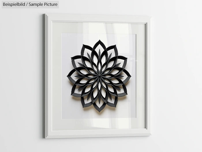 3D black geometric flower artwork in a white square frame on a light wall.