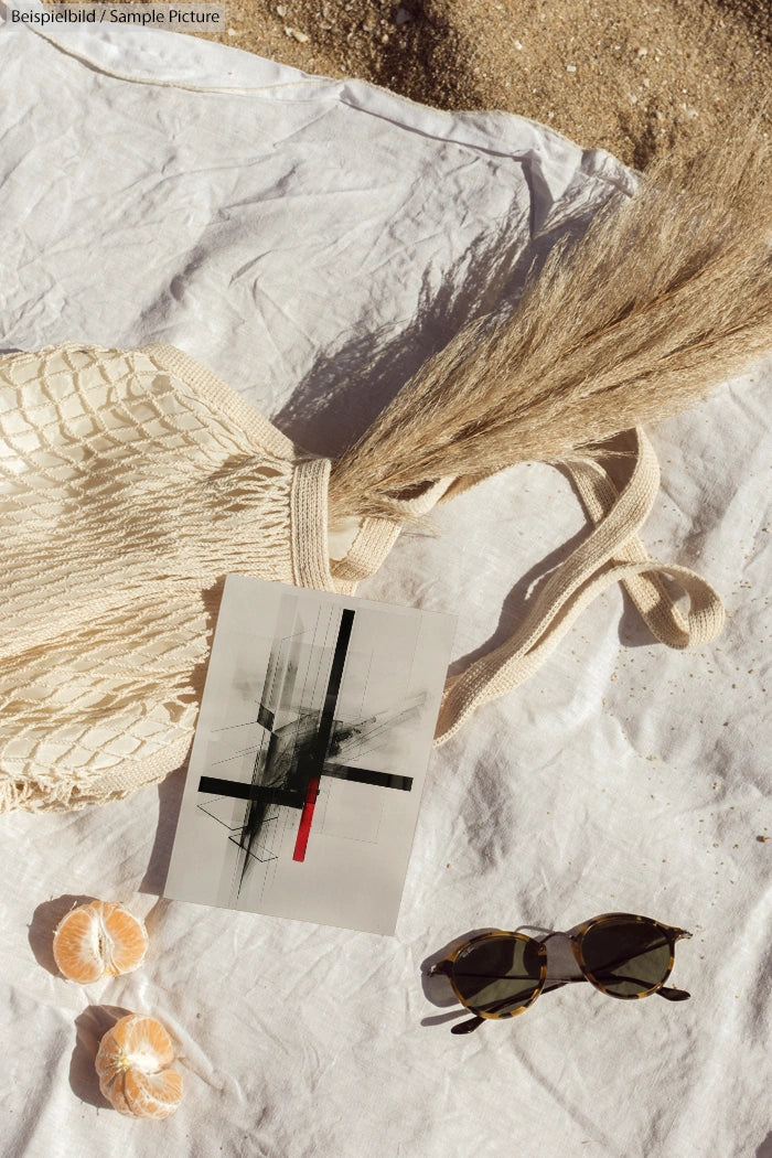 Beach scene with tote bag, abstract art, sunglasses, and sliced oranges on white fabric.