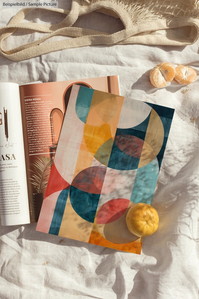 Colorful geometric patterned magazine on linen fabric with oranges nearby.