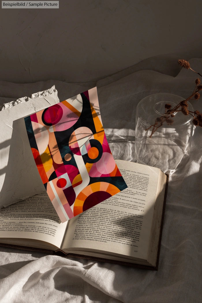 Abstract art print with colorful geometric shapes on an open book under soft natural lighting.