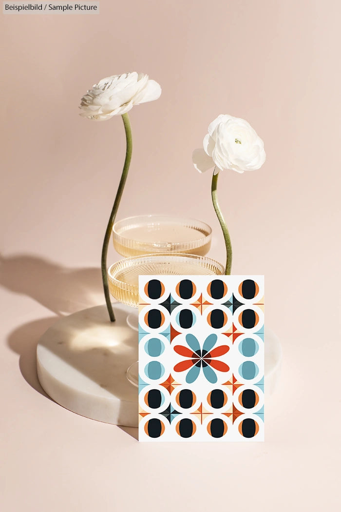 Floral card design with abstract shapes beside white flowers in glass vases on a round white tray.