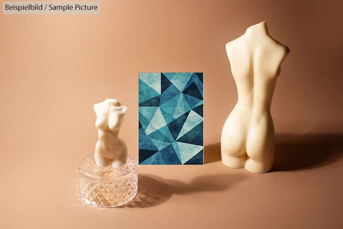 Two torso sculptures beside geometric blue artwork on a beige background.