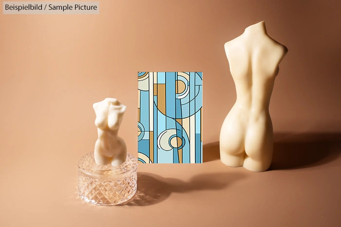 Two torso-shaped candles and abstract art on a brown background.