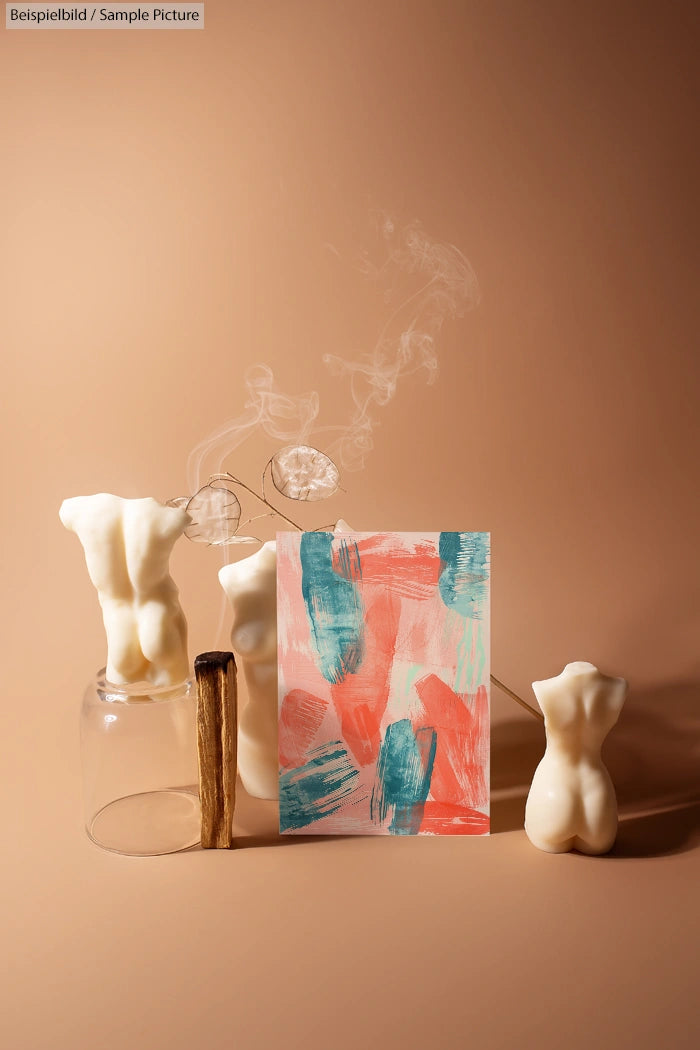 Abstract painting with teal and coral brushstrokes, surrounded by torso-shaped candles and incense smoke on a beige backdrop.