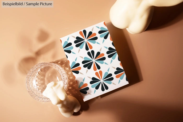 Geometric floral pattern notebook on a brown table with decorative figures.